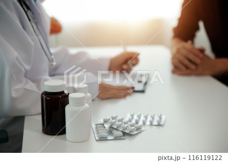 Doctor prescribing medicine giving pills to senior grandmother patient at hospital. 116119122