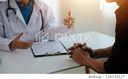 Doctor prescribing medicine giving pills to senior grandmother patient at hospital. 116119127