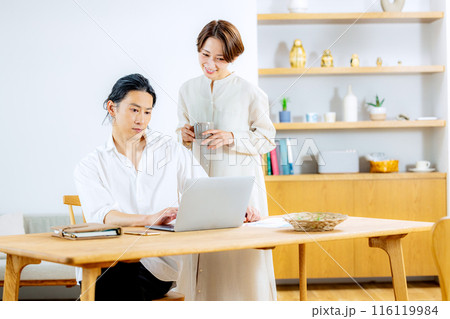 ダイニングでパソコンを見る若い夫婦 116119984