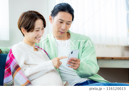 スマホを見る夫婦　妊婦 116120013