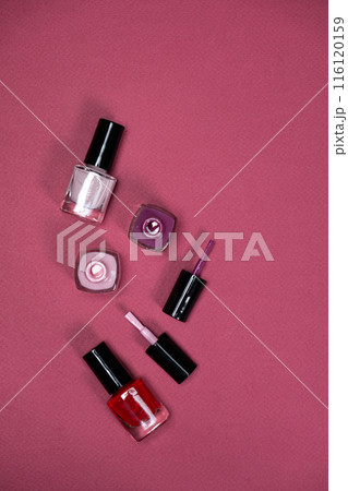 Set of Colorful Bottle Nail Polishes on Pink Background, Space for Text. 116120159