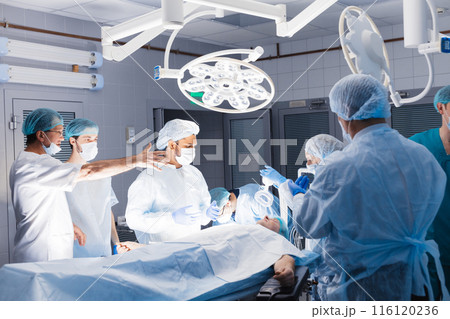 Medical Team Performing Surgical Operation in Bright Modern Operating Room 116120236