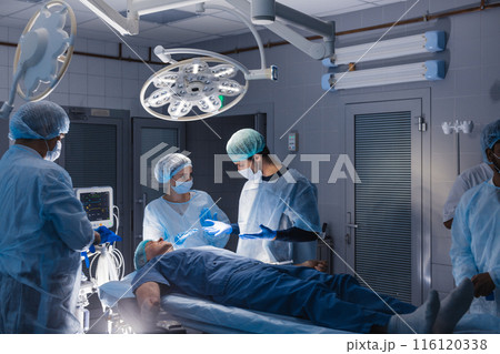 Surgery preparations. Surgical team preparing their patient for surgery Surgery preparations. Surgical team preparing their patient for surgery 116120338