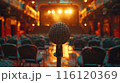 A Single Microphone on Stage in a Dimly Lit Theatre 116120369