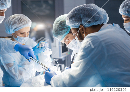 Diverse Team of surgeon, assistants and nurses making invasive surgery 116120393
