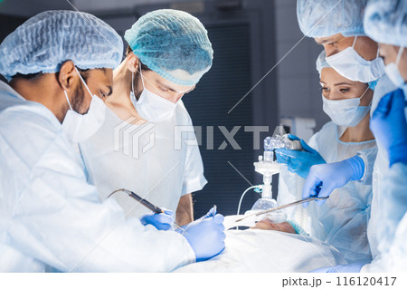 Diverse Team of surgeon, assistants and nurses making invasive surgery Diverse Team of surgeon, assistants and nurses making invasive surgery 116120417