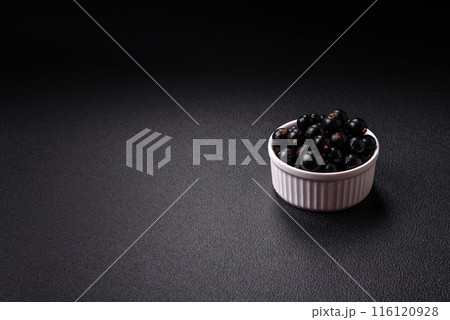 Ripe blackcurrant berries in droplets of water in a ceramic bowl 116120928