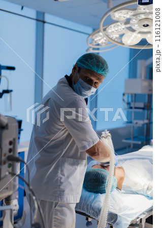 Team of anesthetists preparing patient for surgery at the operating room Team of anesthetists preparing patient for surgery at the operating room 116121008