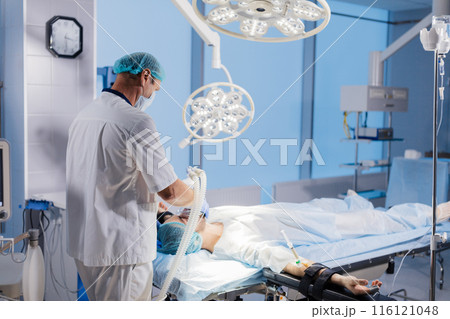 Medical Team Performing Surgical Operation in Bright Modern Operating Room 116121048