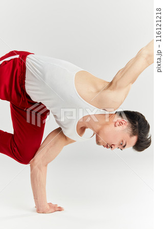 Asian male breakdancer dancing on white background, doing shoulder freeze stance 116121218