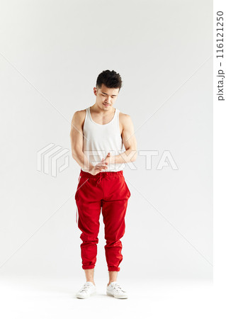 Korean gymnast in white undershirt and red sweatpants looking at camera. 116121250