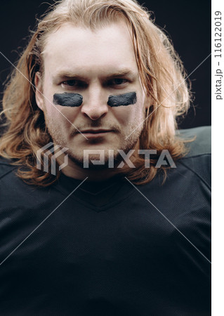 Determined American football player posing with painted face and chewing gum 116122019
