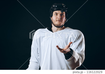 Hockey player bites the puck with broken teeth and looking at camera with a grin. Hockey player bites the puck with broken teeth and looking at camera with a grin. 116122029