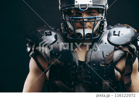 Portrait of american football player in protective shields on naked torso 116122072