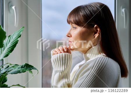 Profile view of beautiful happy mature woman looking out the window Profile view of beautiful happy mature woman looking out the window 116122289