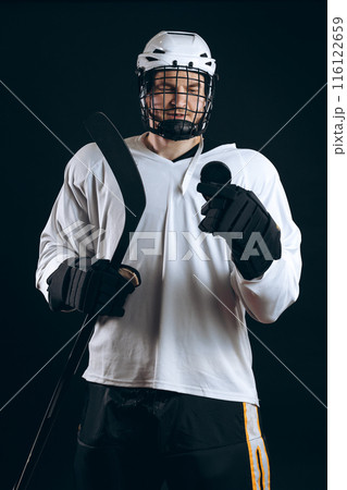 Handsome hockey player. Smiling at camera isolated on black background. 116122659
