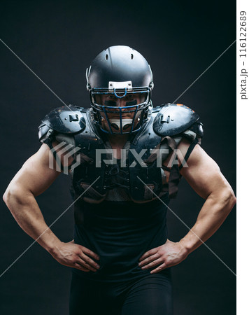 Portrait of american football player in protective shields on naked torso Portrait of american football player in protective shields on naked torso 116122689