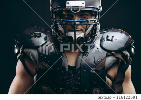 Portrait of american football player in protective shields on naked torso 116122691