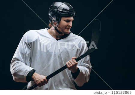 Handsome hockey player. Smiling at camera isolated on black background. 116122865