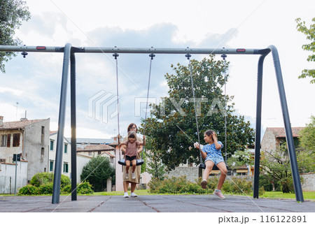 mother with two daughters in children playground mother with two daughters in children playground 116122891