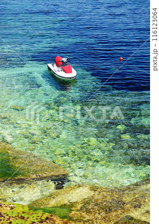 The turquoise sea water is near beach and water jet bike, Bugibba, Malta 116123064