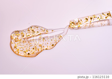 Pipette with 24k gold serum on a pink background. 116123110