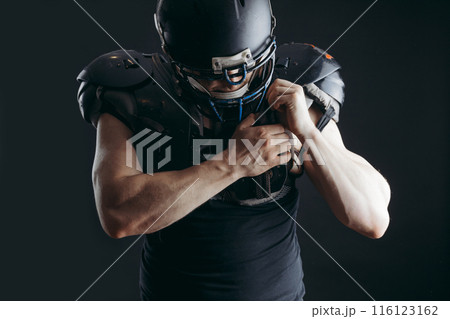 American football player with ball wearing helmet and protective shields 116123162