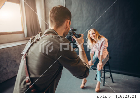 young active photographer using his new modern camera at work 116123321