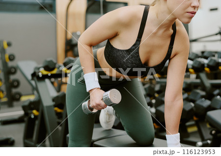Medium close up of female body doing exercise for shoulder and back muscles Medium close up of female body doing exercise for shoulder and back muscles 116123953