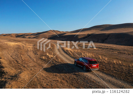 Red Car Driving on Dirt Road 116124282