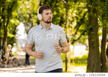 Athletic fitness sport runner man training marathon run listening music in headphones workout cardio Athletic fitness sport runner man training marathon run listening music in headphones workout cardio 116124394