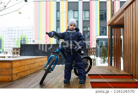 European boy dressed in winter clothes took his bike outside European boy dressed in winter clothes took his bike outside 116126570
