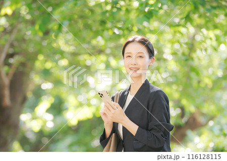 スマホを持つスーツの女性 116128115
