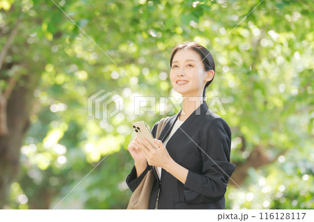 スマホを持つスーツの女性 116128117