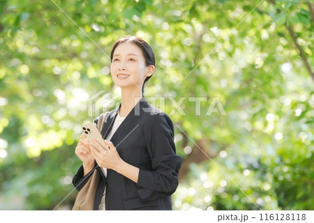 スマホを持つスーツの女性 116128118