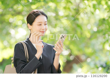 スマホを持つスーツの女性 スマホを持つスーツの女性 116128200