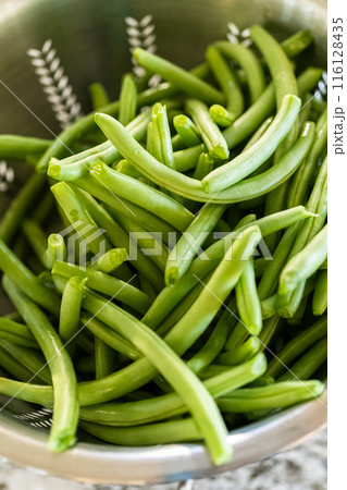 Watch as fresh green beans are beautifully roasted to perfection on a baking sheet with a silicone mat, adding a burst of flavor to your meal. 116128435