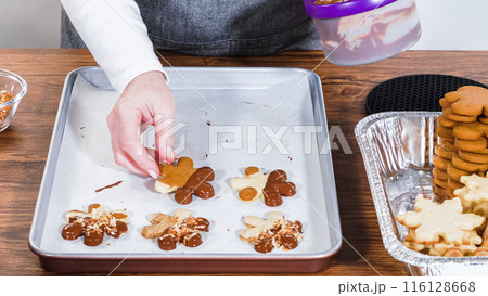 Crafting star-shaped holiday cookies dipped in chocolate and sprinkled with variety of toppings. 116128668