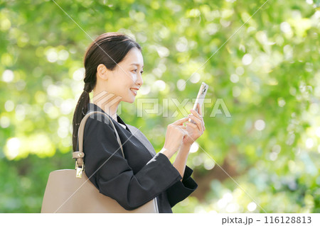 スマホを持つスーツの女性の横顔 スマホを持つスーツの女性の横顔 116128813