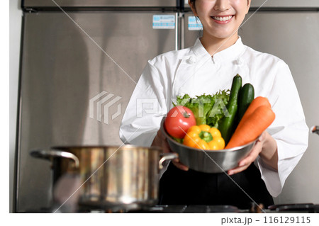 沢山の野菜を持つ若いアジア人の女性調理師 116129115