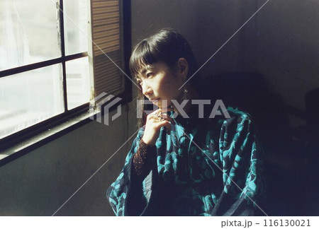 アンティークな椅子に座り思考する女性 116130021