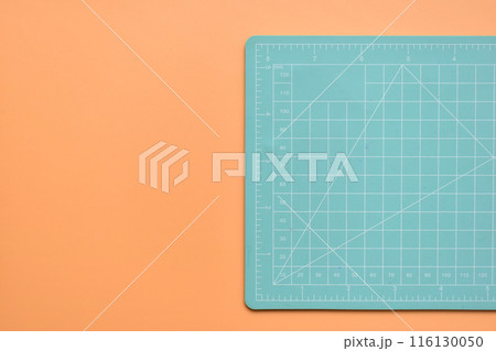 green cutting mat on orange background, object tool for design green cutting mat on orange background, object tool for design 116130050