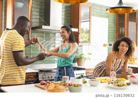 A group of friends is enjoying time together in a bright kitchen 116130632