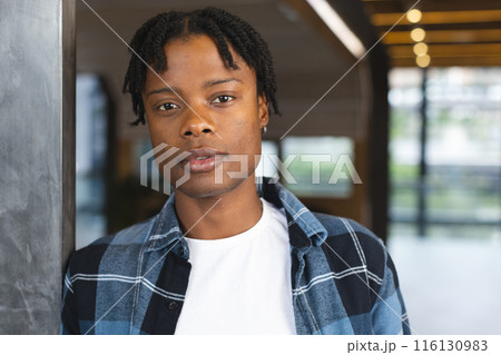 African American man standing, looking directly at camera in a modern business office African American man standing, looking directly at camera in a modern business office 116130983
