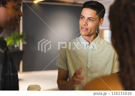 Diverse group of colleagues talking in a modern business office, biracial man in focus 116131010
