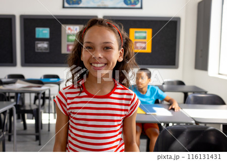 In school, in the classroom, a biracial girl and boy are focusing on learning In school, in the classroom, a biracial girl and boy are focusing on learning 116131431