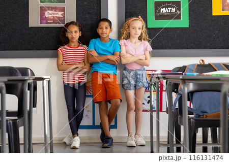 In school, diverse group of young students standing together in the classroom 116131474