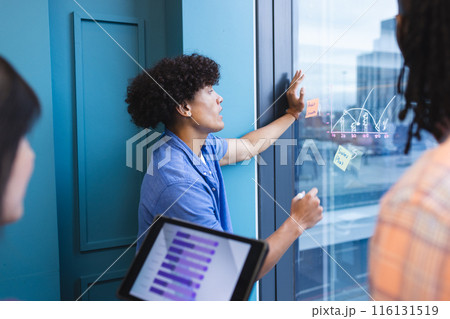 A diverse group of young adults is brainstorming with sticky notes in a modern business office A diverse group of young adults is brainstorming with sticky notes in a modern business office 116131519
