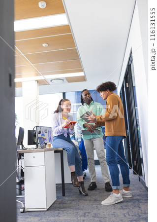 Diverse group of young colleagues discussing in office 116131555