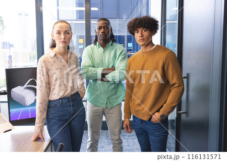 Diverse team standing in office, looking serious 116131571